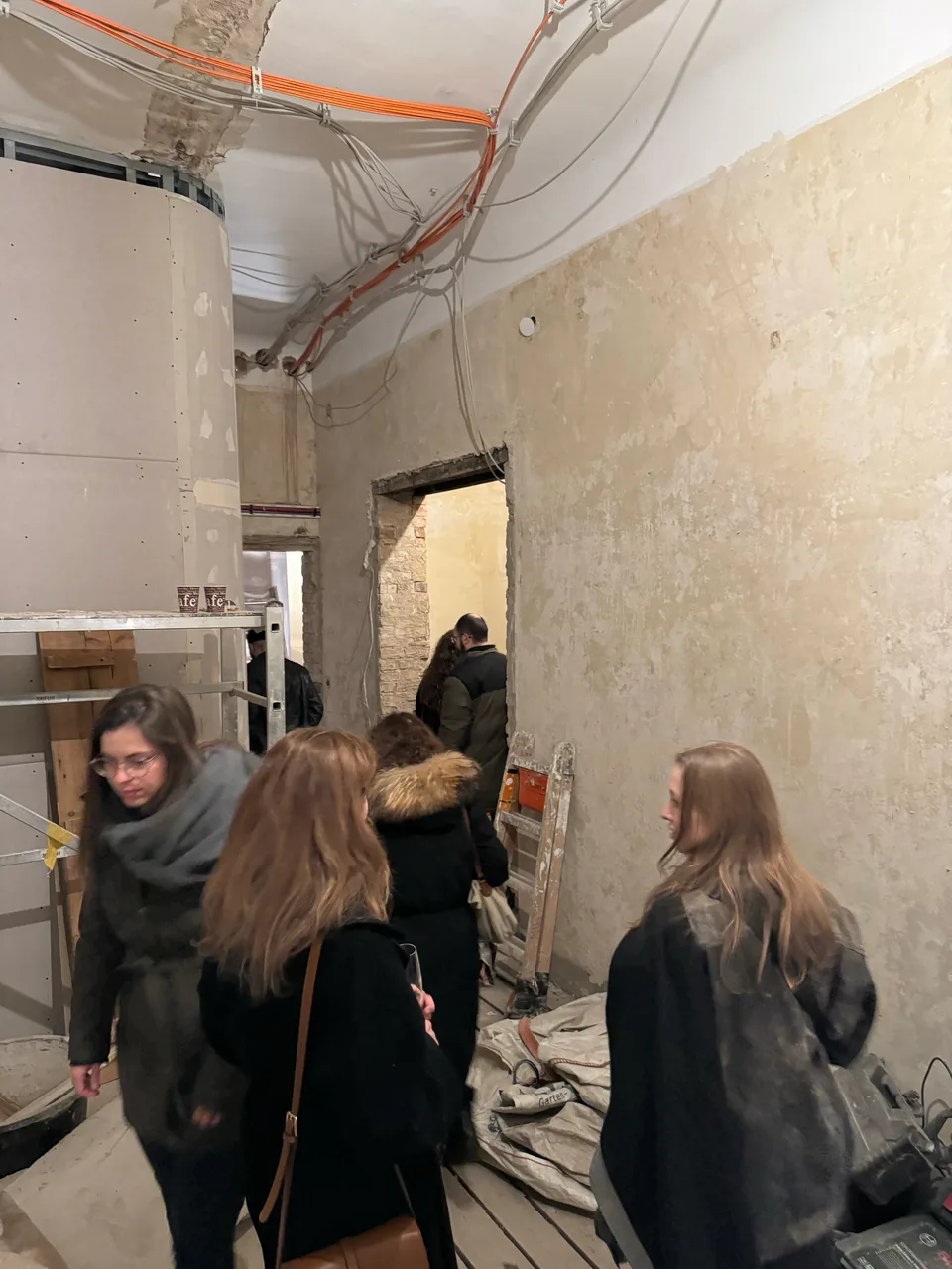 Besichtigung eines Rohbaus mit offenen Kabeln an der Decke