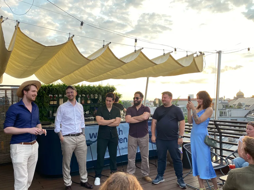 Rede unter dem Sonnensegel, das Team hört auf der Dachterrasse zu