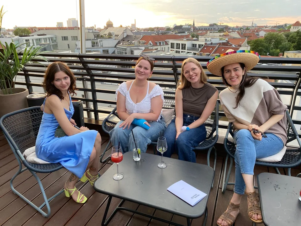 Vier Kolleginnen auf der Dachterrasse vor der Berliner Skyline