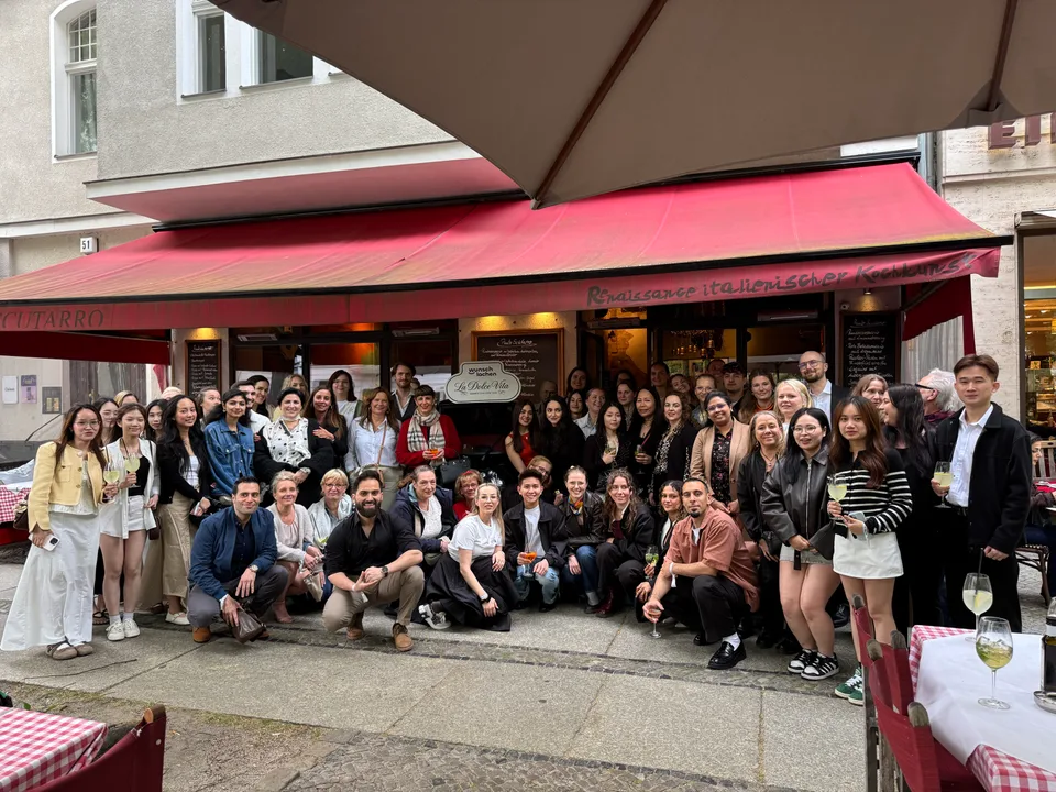 Großes Gruppenbild des Teams vor der roten Markise des Restaurants