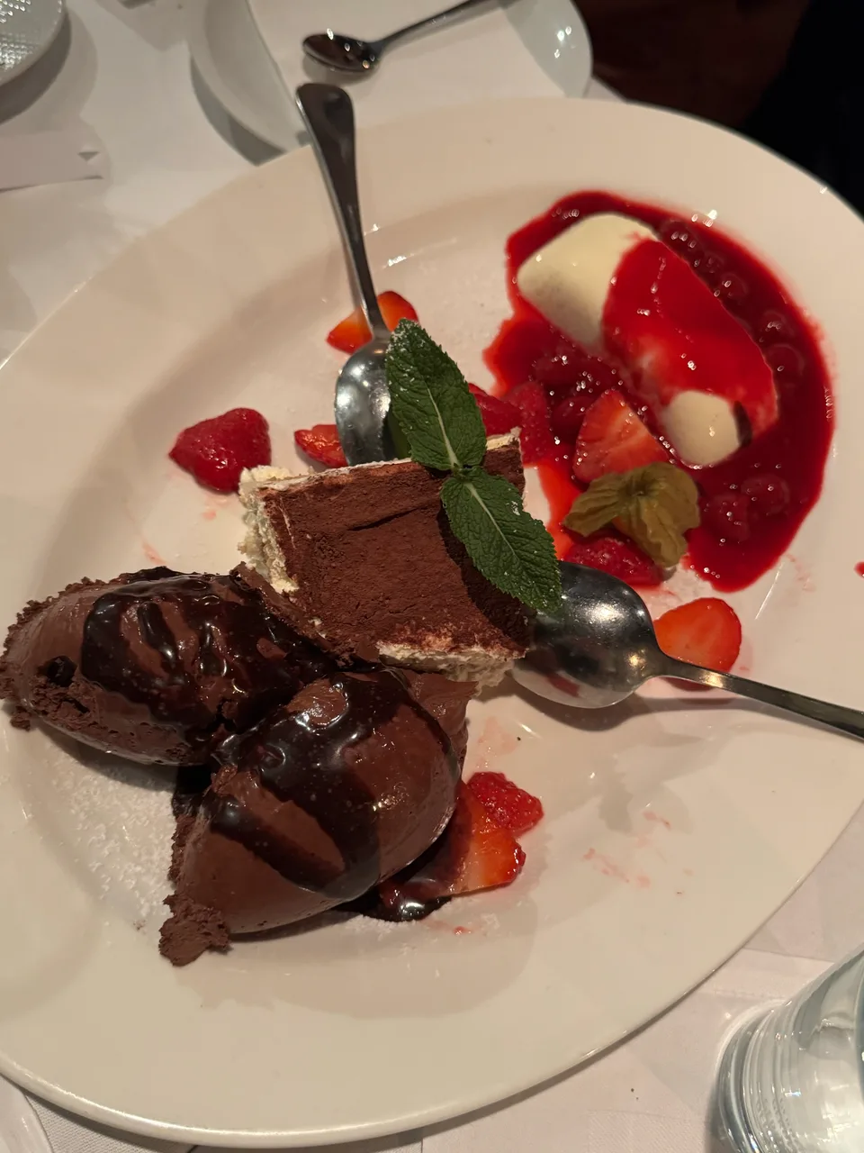 Dessertteller mit Schokoladenmousse, Tiramisu, Panna cotta und Erdbeeren
