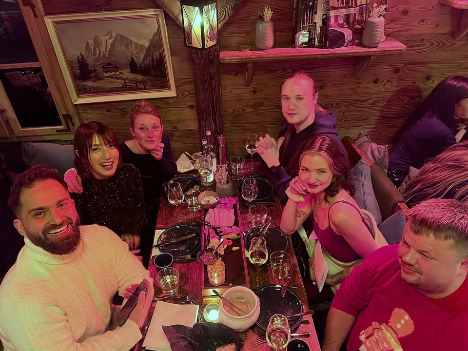 Lachende Tischrunde in der Holzhütte bei der Weihnachtsfeier