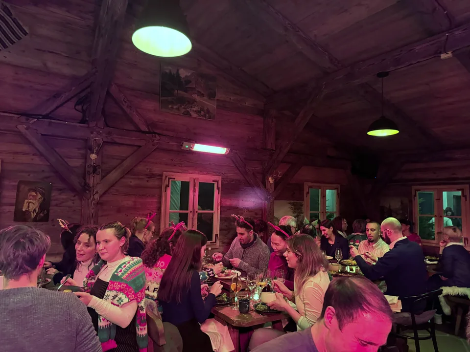 Voller Hüttensaal mit Rentier-Haarreifen beim Weihnachtsessen