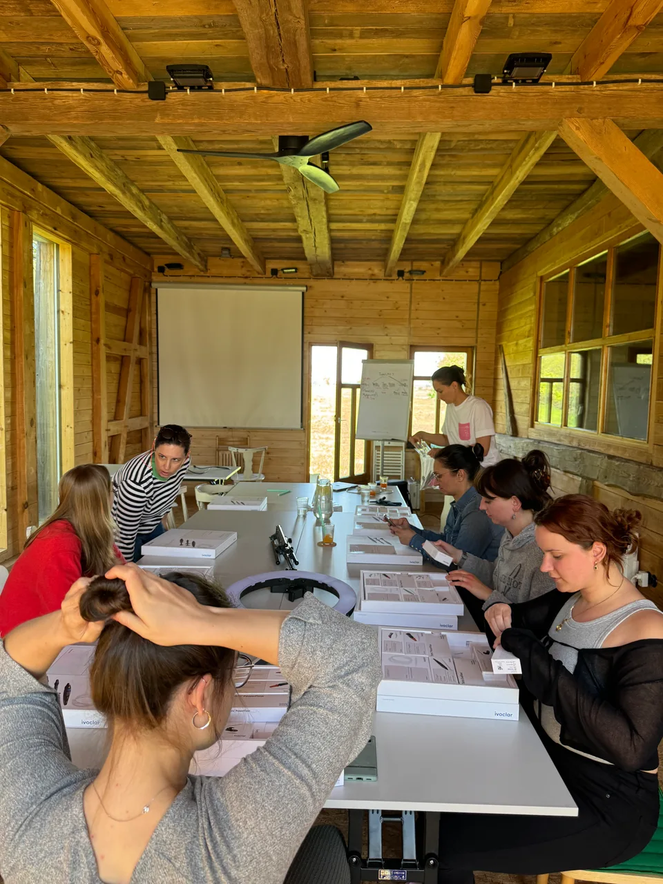 Team arbeitet am langen Tisch in der Holzscheune