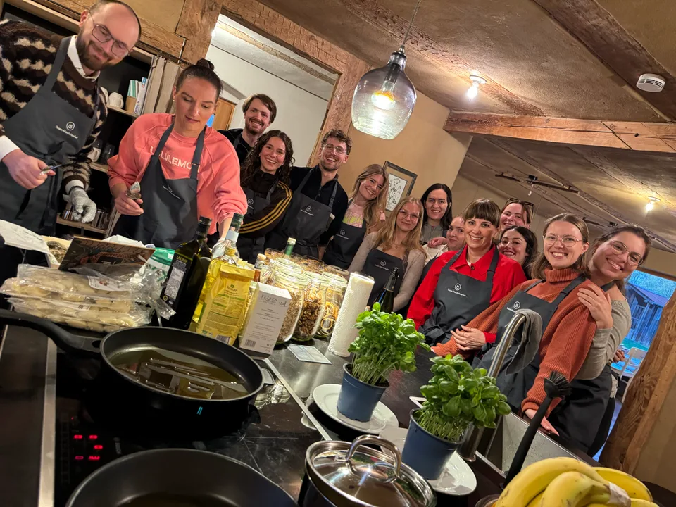 Team in Schürzen beim Kochabend in der Holzküche