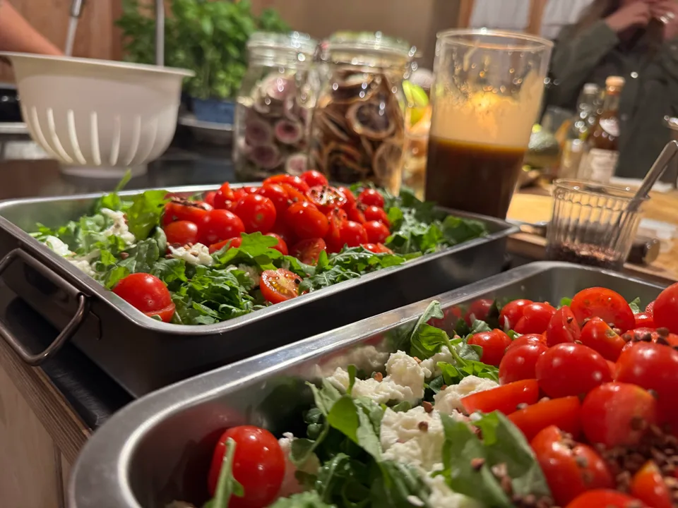 Bleche mit Tomaten-Rucola-Salat in der Küche