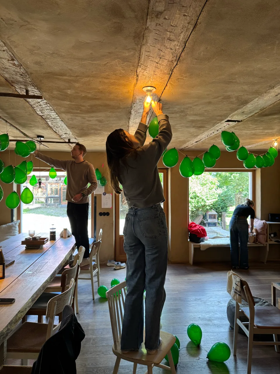 Grüne Luftballons werden an die Deckenbalken gehängt