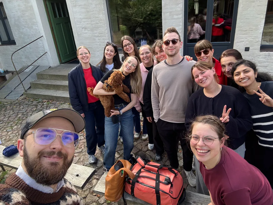 Fröhliches Gruppenselfie mit Hund im gepflasterten Hof